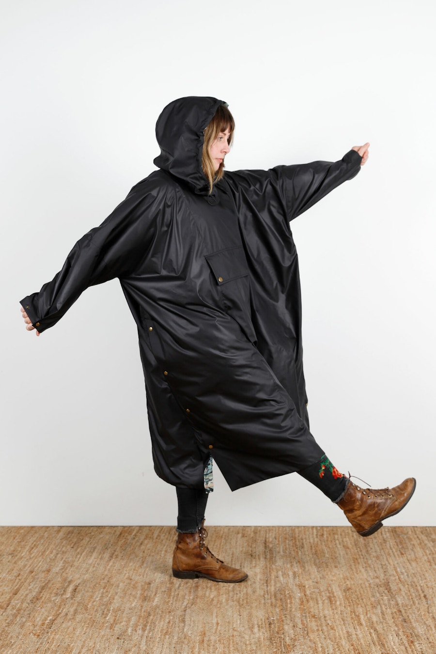 Becca Assembly Line Hoodie Poncho Black Side Hood Up Walk Arms Out